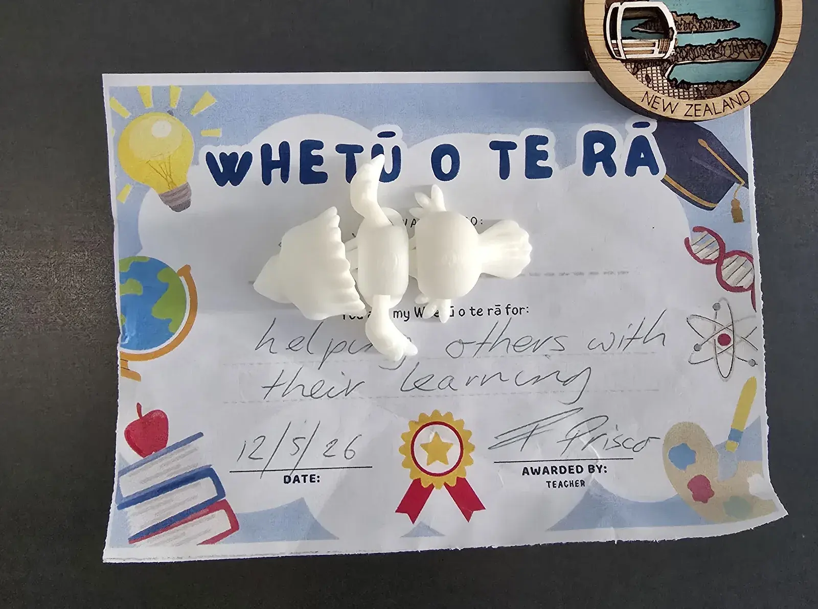 A CritterPals magnet pinning a child's school award to the fridge